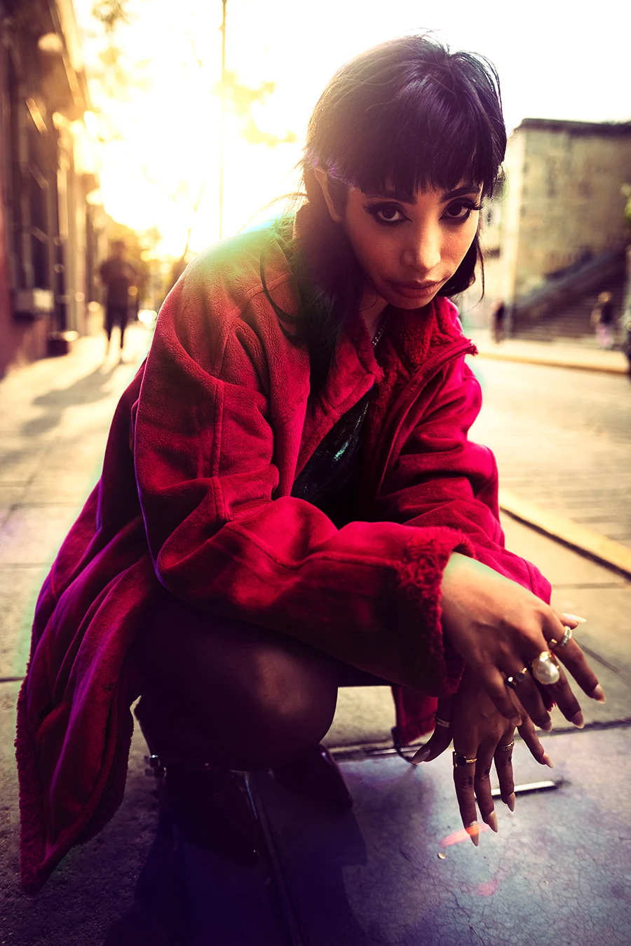a woman squatting on the sidewalk