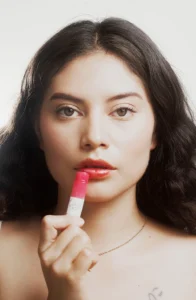 a woman with a lipstick in front of her face