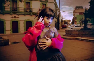 mujer usando abrigo rojo en un parque de Oaxaca