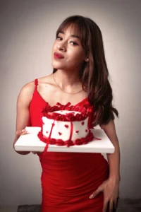 mujer posando para una foto mientras sostiene un pastel