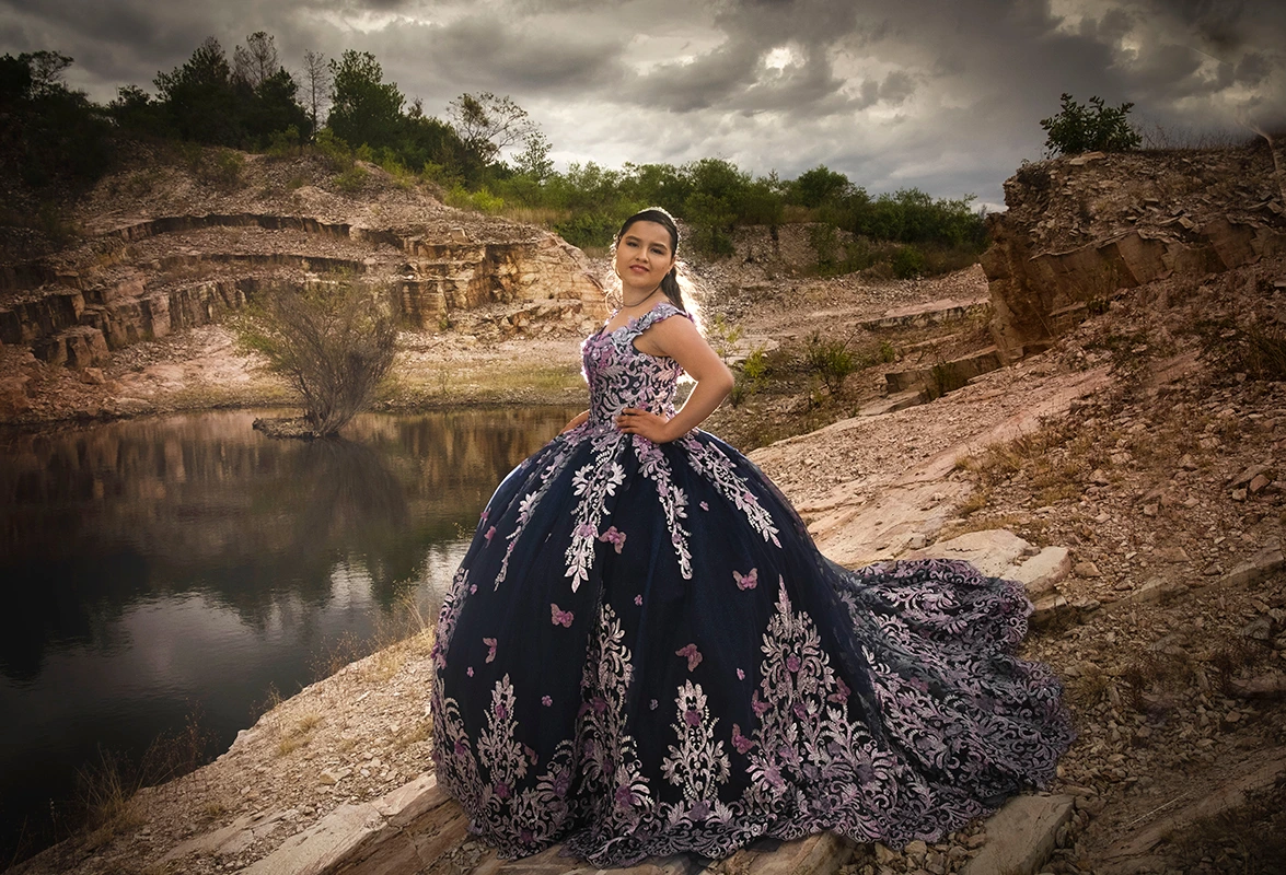Mujer con vestido azul posando en un lago