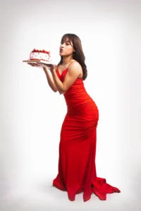 mujer vestida de rojo sosteniendo un pastel con sus dos manos