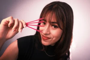 a woman holding a few pink brushes